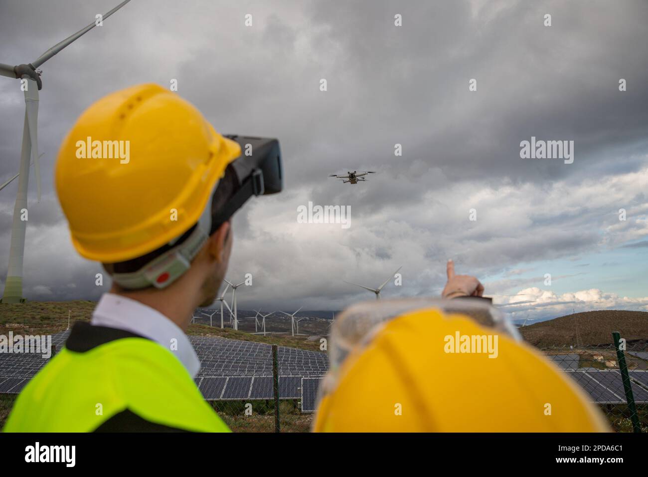 Deux ingénieurs font voler un drone à une centrale solaire, un concept d'énergie durable et propre. Banque D'Images