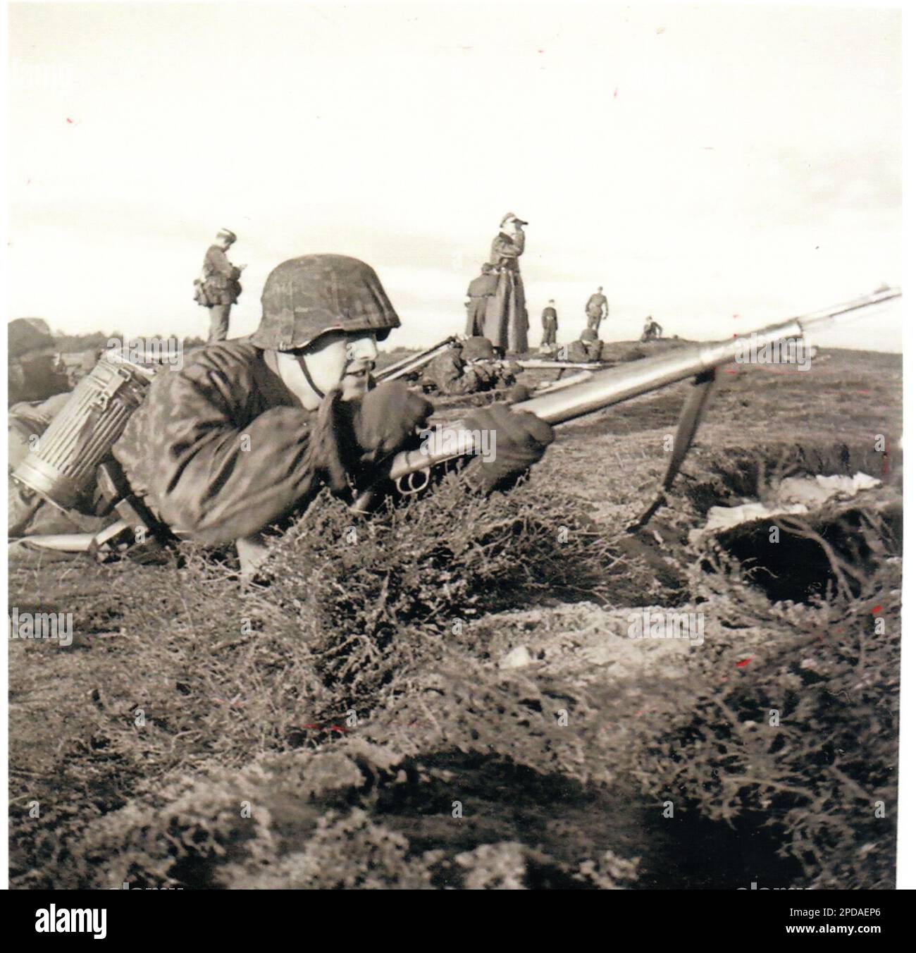 Photo B&W de la Seconde Guerre mondiale un soldat allemand dans un Smock de Camo charge son fusil en entraînement Banque D'Images