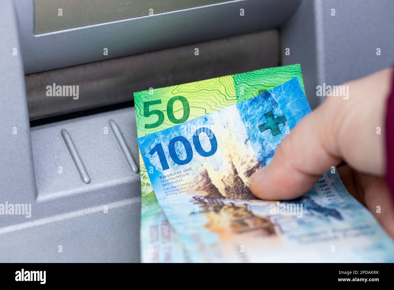 La femme détient de l'argent suisse prélevé sur un guichet automatique, des billets en papier de 100 et 50 francs Banque D'Images