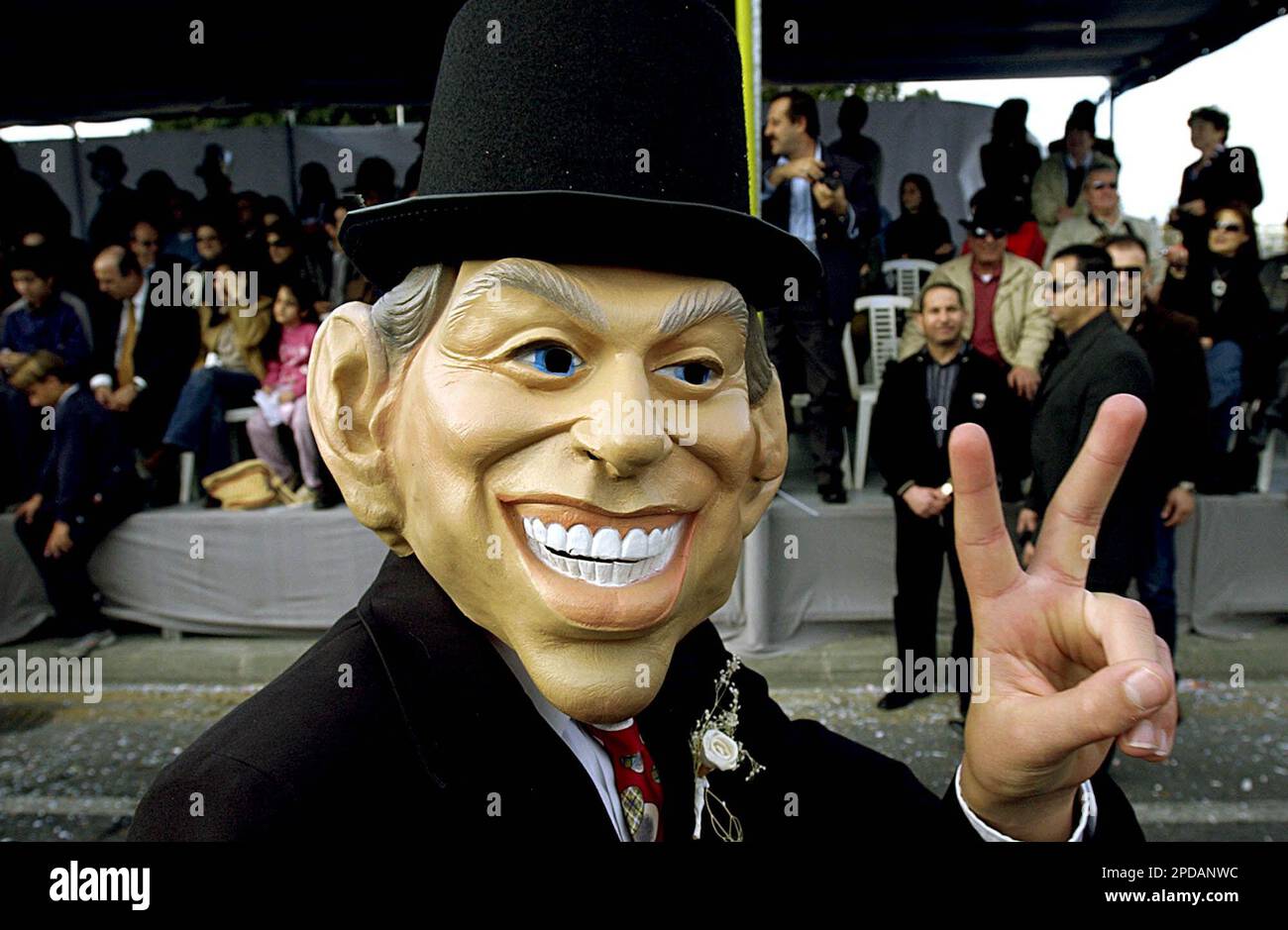 A man with a British Prime Minister Tony Blair carnival mask takes part in a traditional parade to mark the end of the carnival period in the southern port city of Limassol, 83 kilometers (52 miles) south of the capital Nicosia, Cyprus, on Sunday, March 5, 2006. Thousands of people gather every year to celebrate the Carnival in the streets. (AP Photo/Petros Karadjias) Banque D'Images