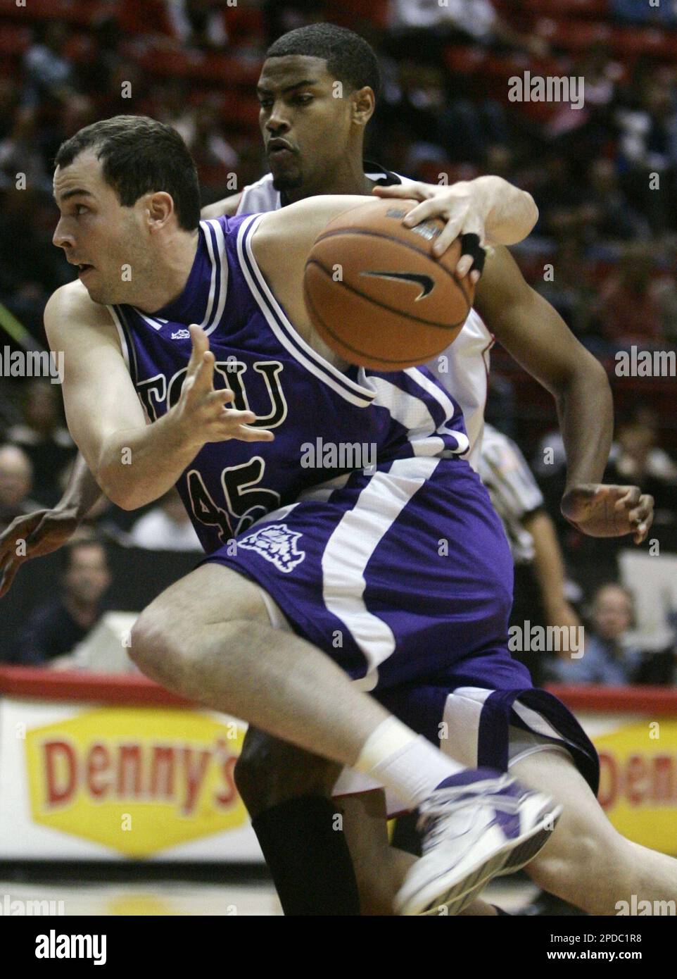 Texas Christian's Art Pierce drives past San Diego State's Mohamed Abukar while going for the basket during the first half of a college basketball game Saturday, Feb. 18, 2006, in San Diego. (AP Photo/Lenny Ignelzi) Banque D'Images