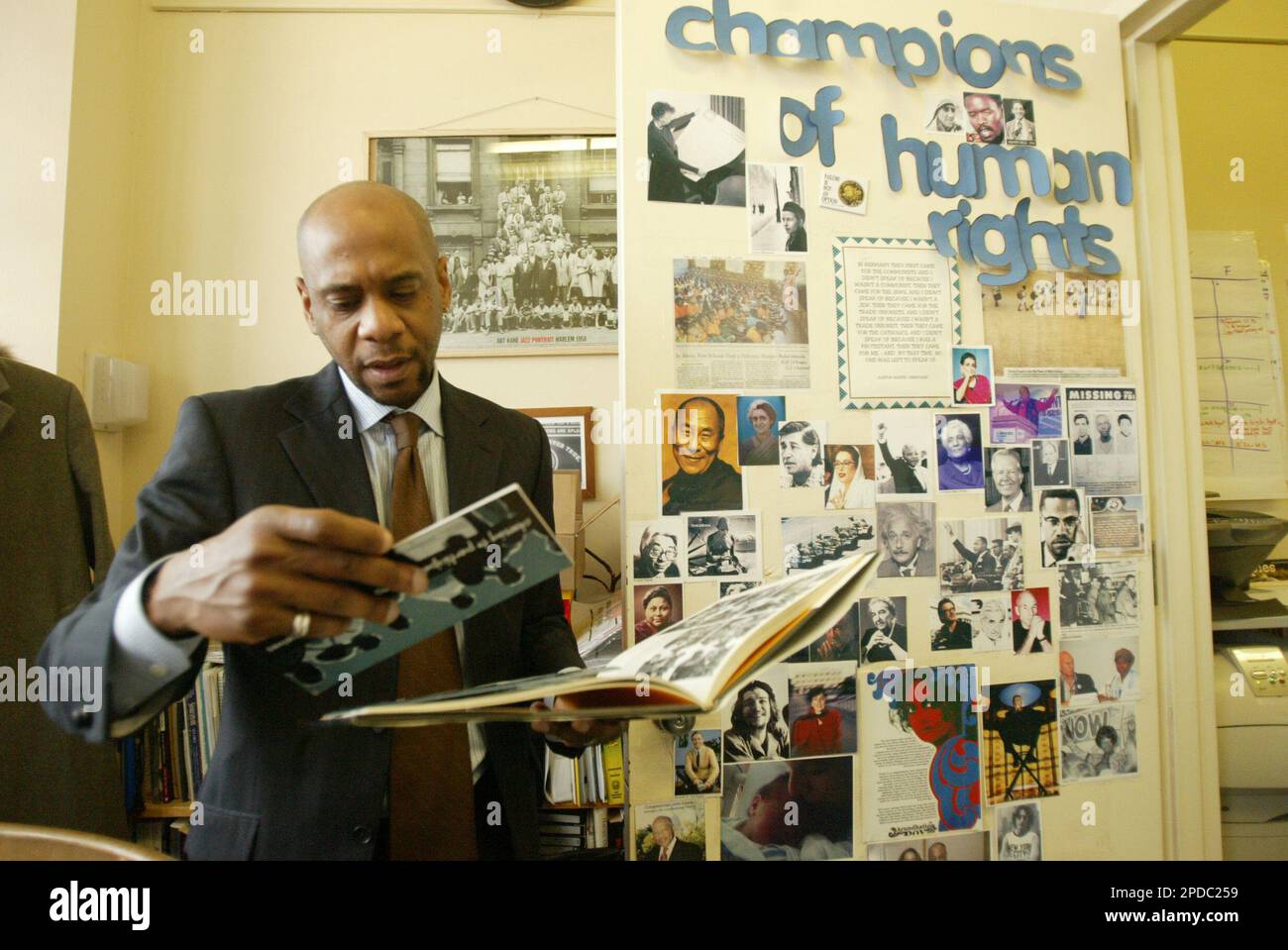 **ADVANCE FOR MONDAY FEB. 20**The School for Human Rights Principal Kevin Dotson looks over the book "A Life is More than a Moment" during an interview in his office Monday, Feb 6, 2006, in the Brooklyn borough of New York. The School for Human Rights is one of nearly 150 "small" public schools that opened through special initiatives in New York City in the last three years. (AP Photo/Mary Altaffer) Banque D'Images
