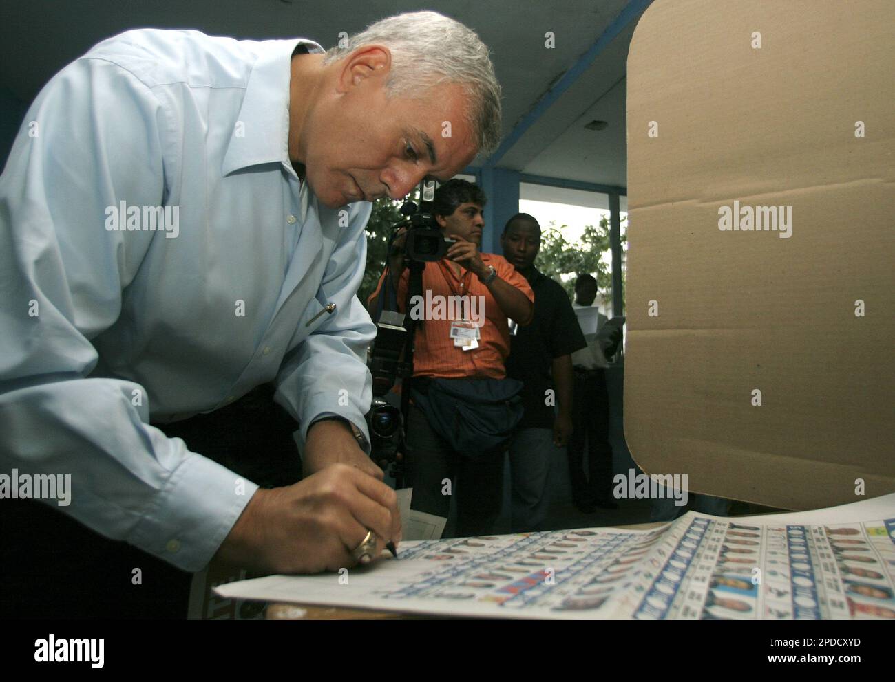 Haitian presidential candidate Charles Henri Baker marks his ballot in the Laboule suburb of Port-au-Prince, Haiti, Tuesday, Feb. 7, 2006. Haitians jammed polling stations as U.N. peacekeepers fanned out to guard the country's first presidential election in nearly six years. (AP Photo/Ramon Espinosa) Banque D'Images