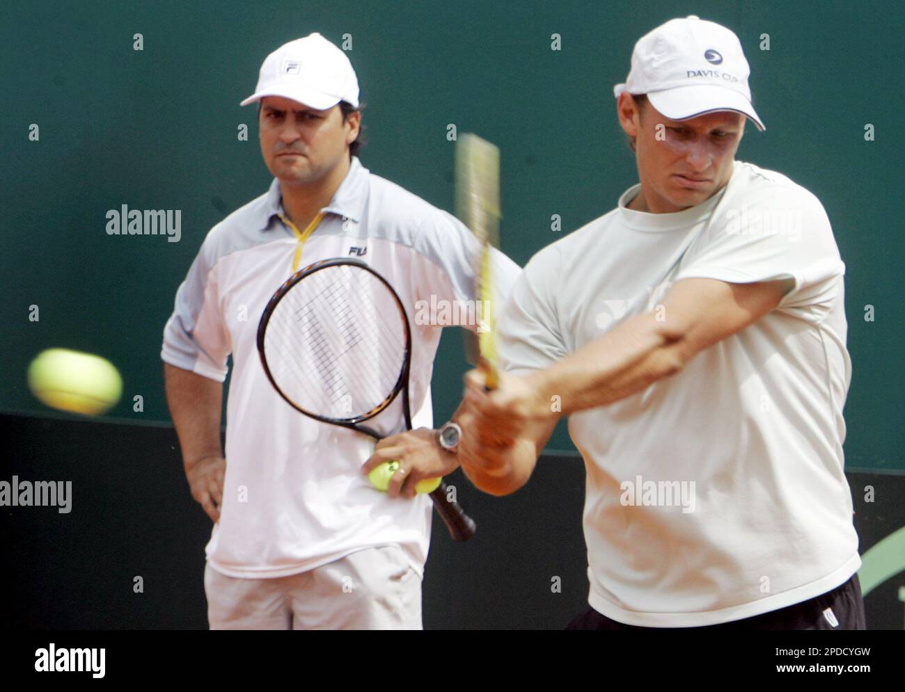 Argentina's David Nalbandian, right, returns the ball while team captian Alberto Mancini watches during a training session in Buenos Aires, Argentina Tuesday Feb. 7, 2006. Argentina will face Sweden for the Davis Cup World Group first round in Buenos Aires from Feb. 10 to Feb. 12. (AP Photo/Natacha Pisarenko) Banque D'Images