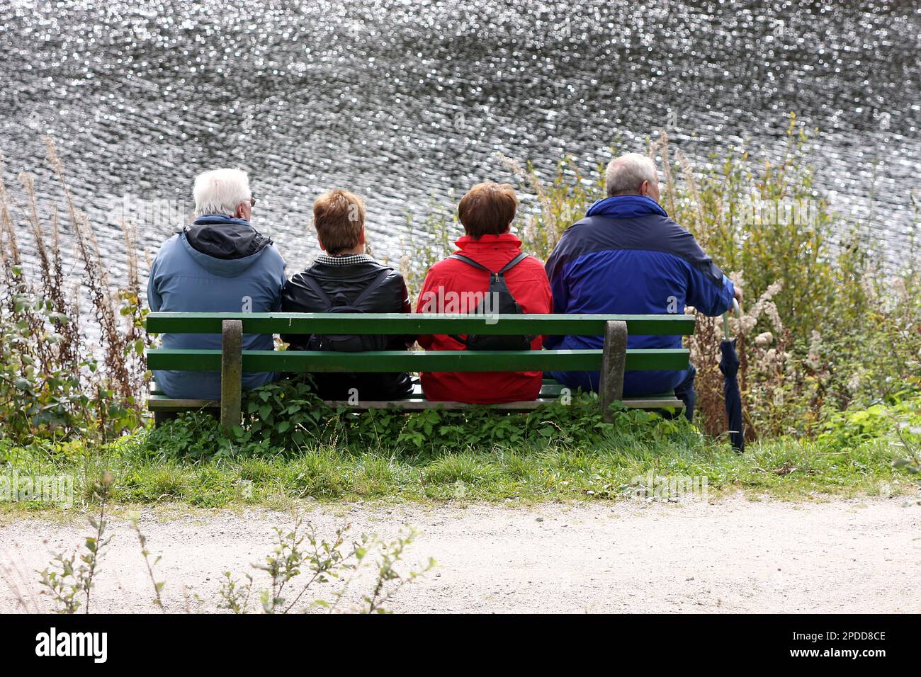 quatre randonneurs assis sur un banc sur la banque Banque D'Images