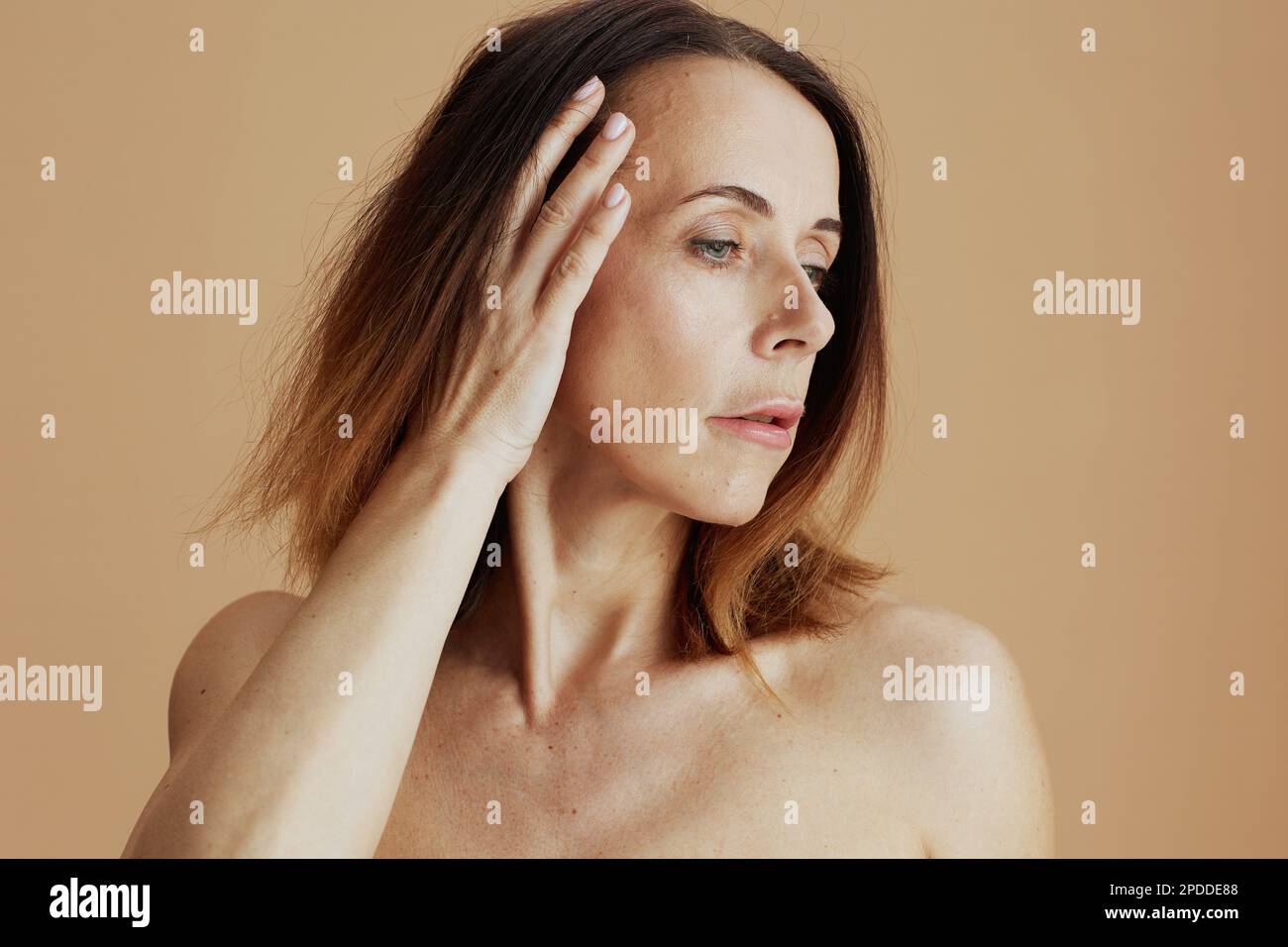 femme moderne de 40 ans avec cheveux courts sur fond beige. Banque D'Images