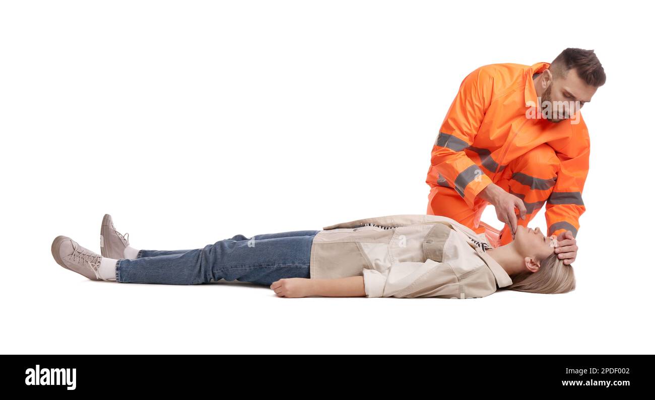 Paramédic en uniforme effectuant les premiers soins sur une femme inconsciente sur fond blanc Banque D'Images