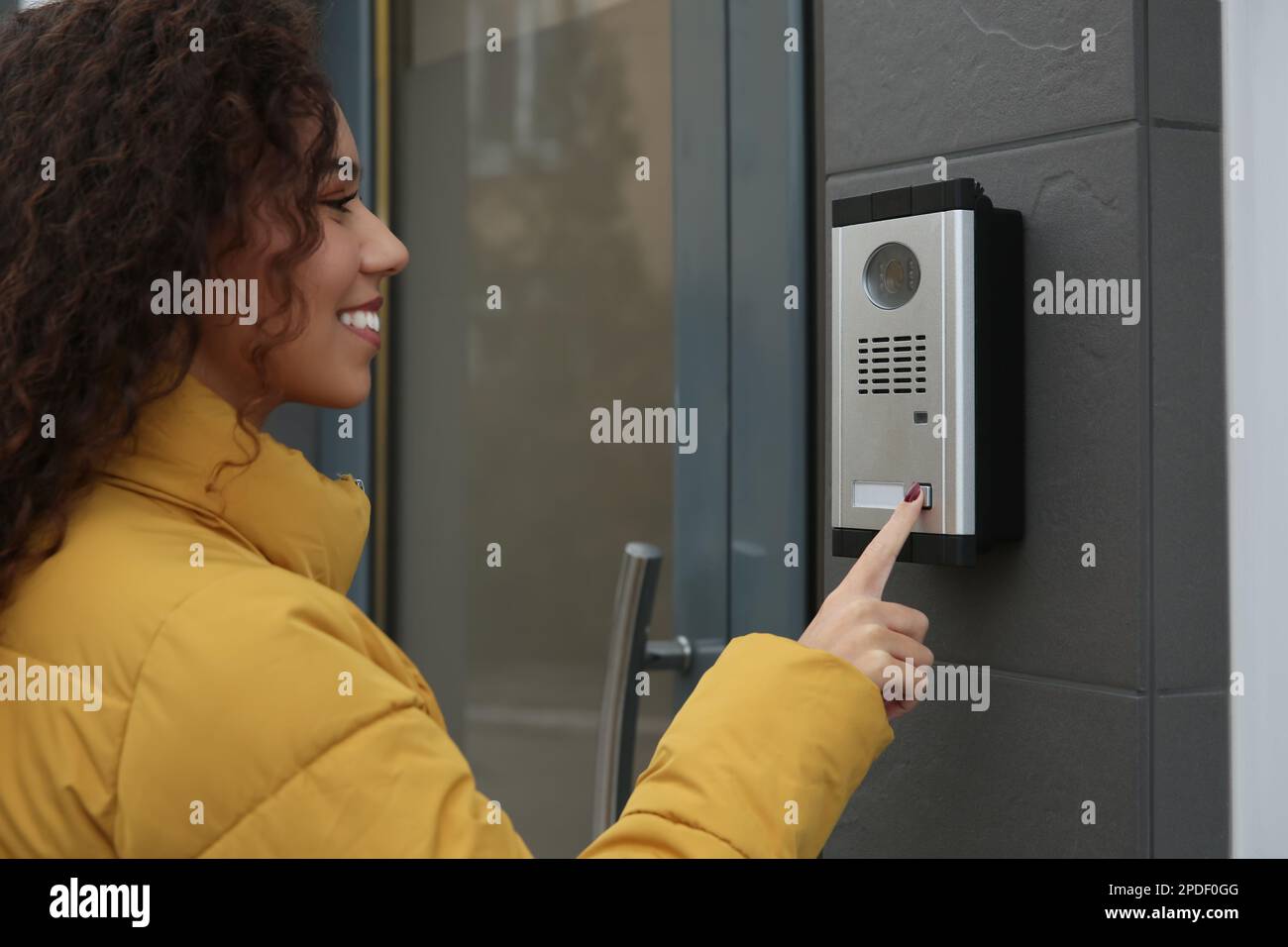 Jeune femme afro-américaine qui sonne dans un interphone avec caméra près  de l'entrée du bâtiment Photo Stock - Alamy
