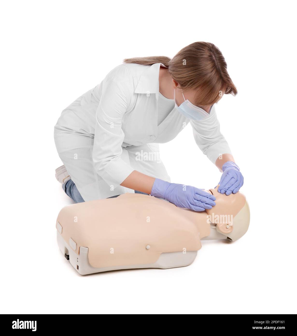 Médecin en uniforme et masque de protection pratiquant les premiers soins sur le mannequin sur fond blanc Banque D'Images