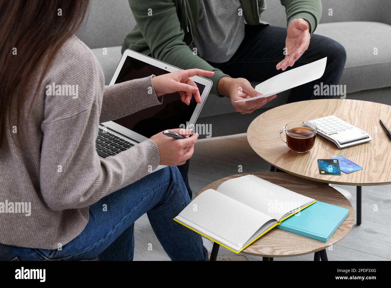 Jeune couple discutant du budget familial à la table à l'intérieur, gros plan Banque D'Images