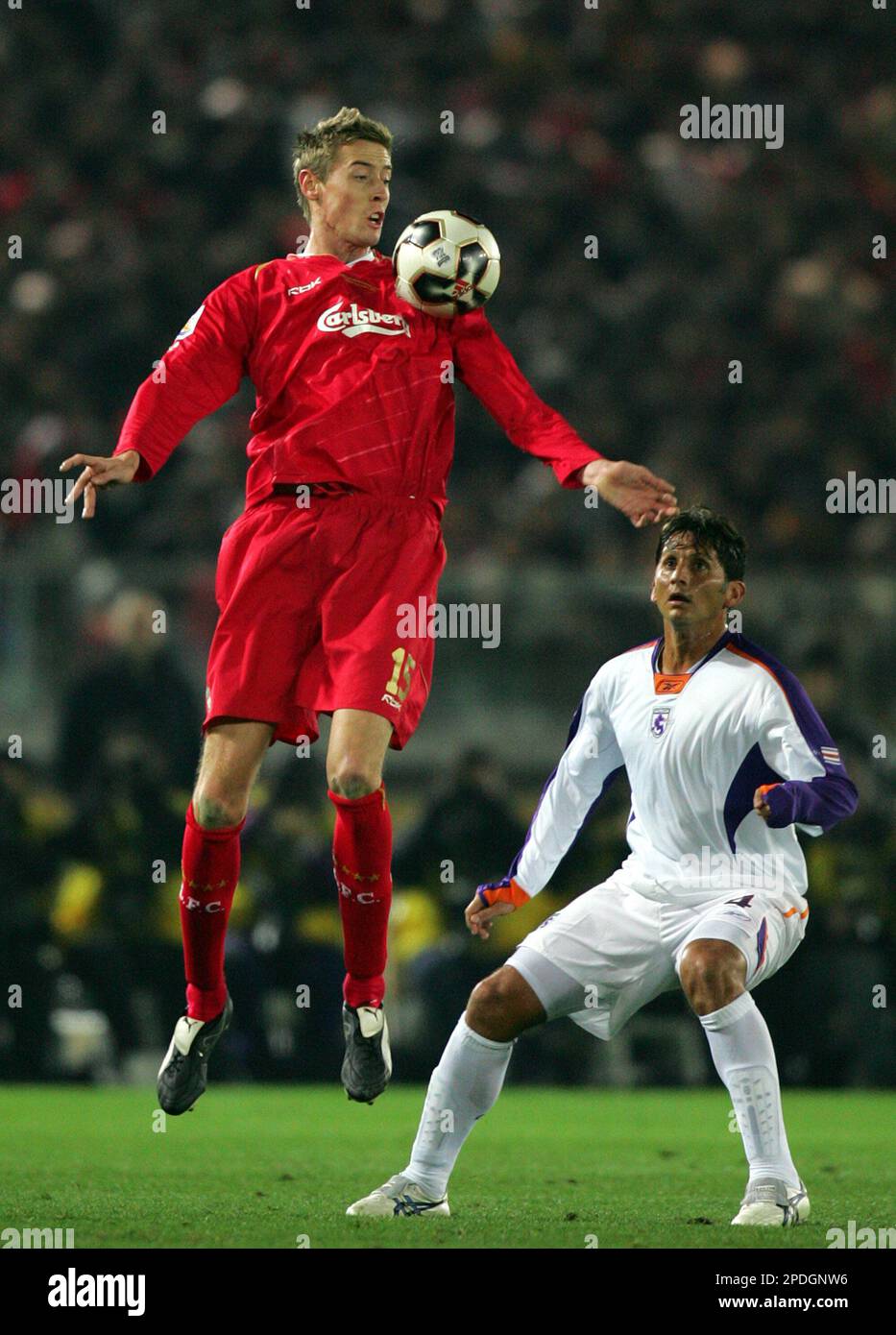 Peter Crouch of Liverpool FC of England jumps to keep the ball as Ronald Gonzalez of Deportivo Saprissa of Costa Rica looks on during the semi-final of FIFA Club World Championship Toyota Cup 2005 in Yokohama, west of Tokyo, Thursday, Dec. 15, 2005. With Couch's first goal European club champion Liverpool leads their North and Central American counterpart Deportivo Saprissa 2-0 in the first half. (AP Photo/Shizuo Kambayashi) Banque D'Images