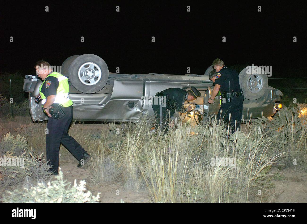 Officers from the Alamogordo Department of Public Safety and the New Mexico State Police investigate a truck which rolled over during a two-vehicle accident on U.S. 70 just south of Airport Road, Saturday, Nov. 26, 2005, in Alamogordo, N.M. (AP Photo/Alamogordo Daily News, Ellis Neel) Banque D'Images