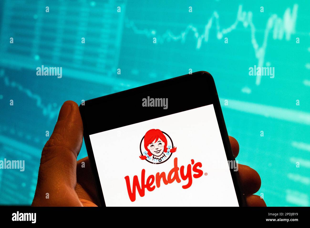 Chine. 15th févr. 2023. Dans cette illustration, le logo de la chaîne de restauration rapide américaine Wendy est affiché sur un smartphone avec un graphique d'indice boursier économique en arrière-plan. Crédit : SOPA Images Limited/Alamy Live News Banque D'Images
