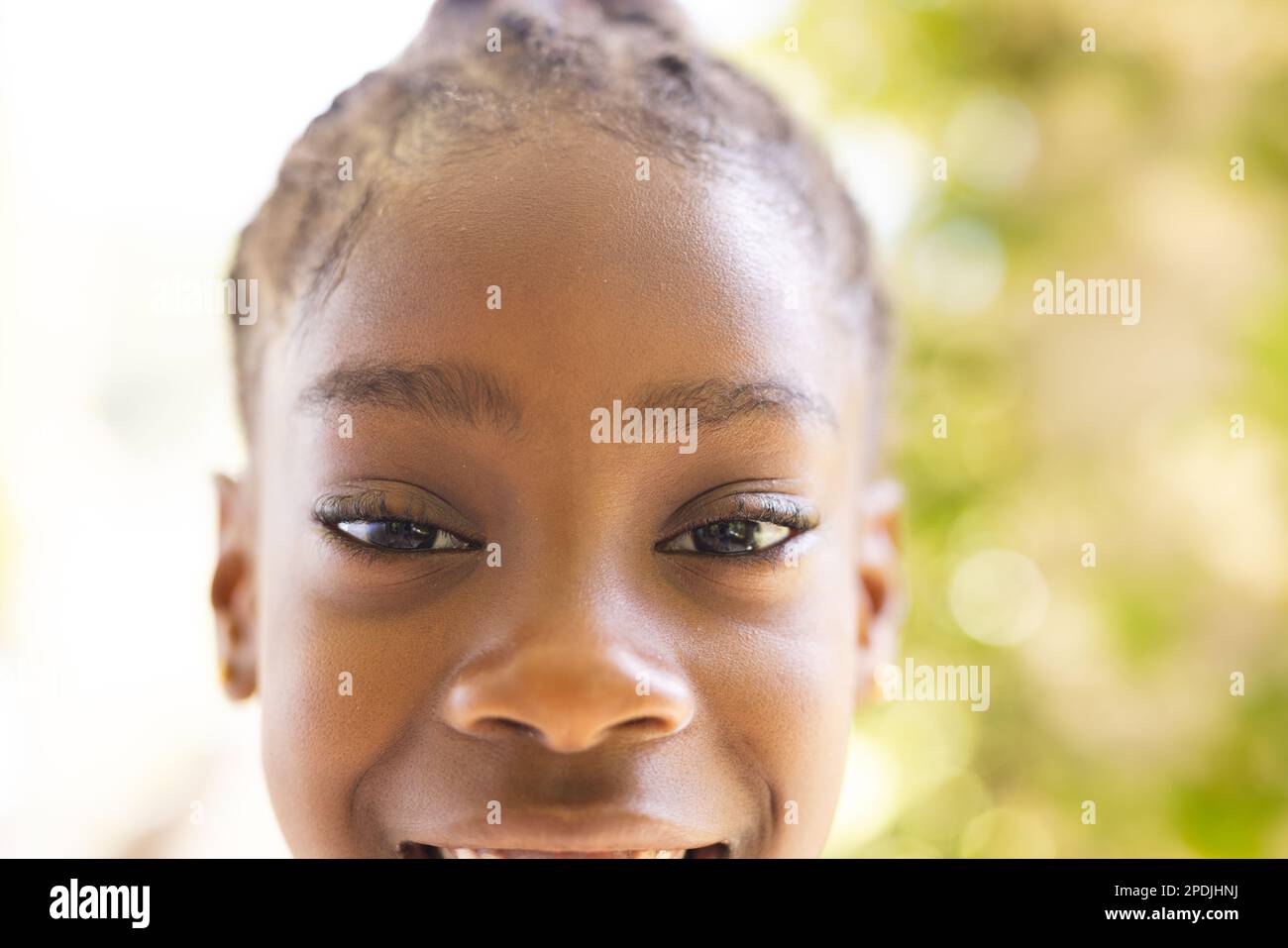 Portrait d'une fille afro-américaine heureuse regardant l'appareil photo et souriant Banque D'Images