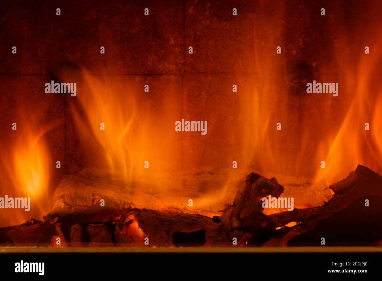 Un merveilleux feu de bois dans un poêle à bois. Un merveilleux feu de bois réchauffant en toute sécurité fermé et visuellement attrayant. J'adore la vue des bûches brûlantes. Banque D'Images