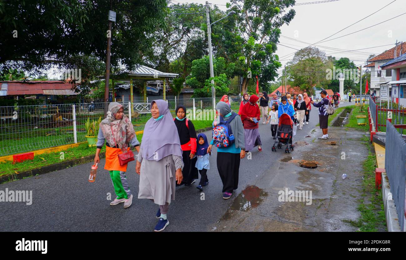 Les femmes d'âge moyen se promenent tranquillement avec leurs familles dans les rues de Muntok City Banque D'Images