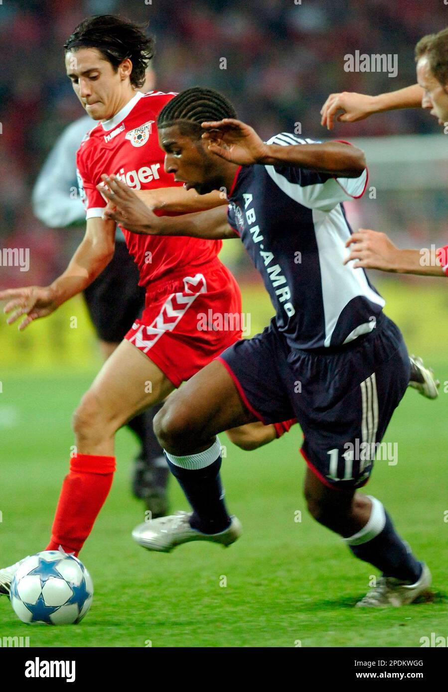 ** CAPTION CORRECTION - CORRECTING POSITIONS ** Nelson Ferreira, left, of Switzerland's FC Thun is tackled by Ryan Babel, right, of Netherland's Ajax Amsterdam, during their UEFA Champions League Group B second leg soccer match in the Wankdorf Stade de Suisse stadium in Bern, Switzerland, on Wednesday, November 2, 2005. (AP Photo/Keystone, Laurent Gillieron) Banque D'Images