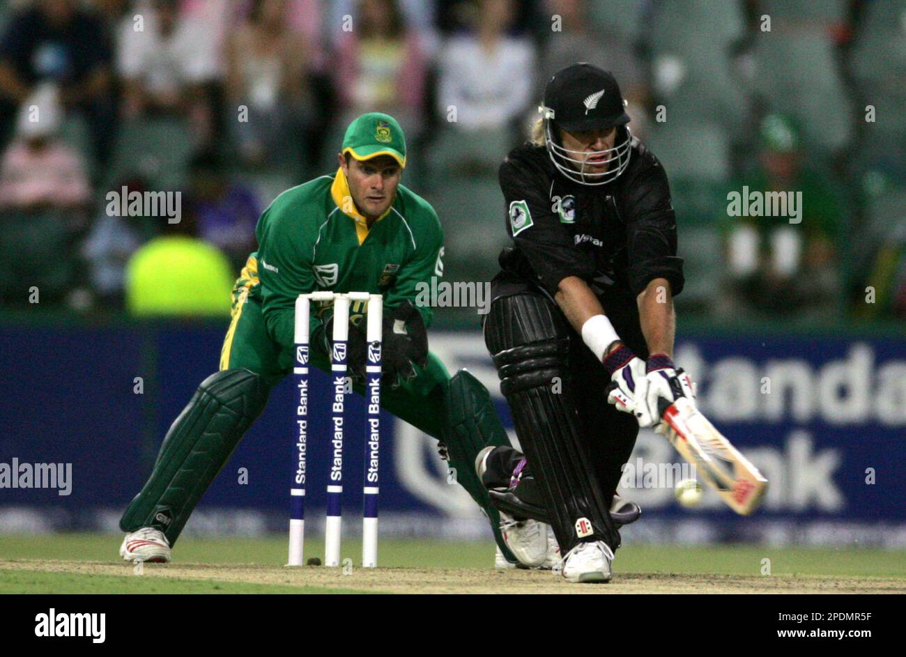 New Zealand's batsman Jacob Oram, right, plays a cut shot as South Africa's wicketkeeper Mark Boucher, left, looks on during the first Pro20 International One-Day Series against South Africa in Johannesburg, South Africa, Friday, Oct. 21, 2005. (AP Photo/Themba Hadebe) Banque D'Images