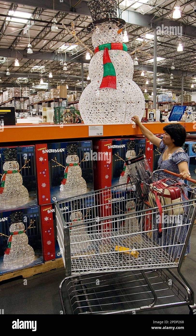 Registered nurse Maggie Lazo from Los Angeles checks a lighted "Snowman" Tuesday, Oct. 4, 2005, at Seasonal section of the Costco Wholesale store in the Los Feliz area of Los Angeles. Costco Wholesale Corp., the leading wholesale club operator in the United States, said Thursday, Oct. 6, 2005, its profit for the fourth quarter rose because of higher revenue and a favorable tax rate. (AP Photo/Damian Dovarganes) Banque D'Images