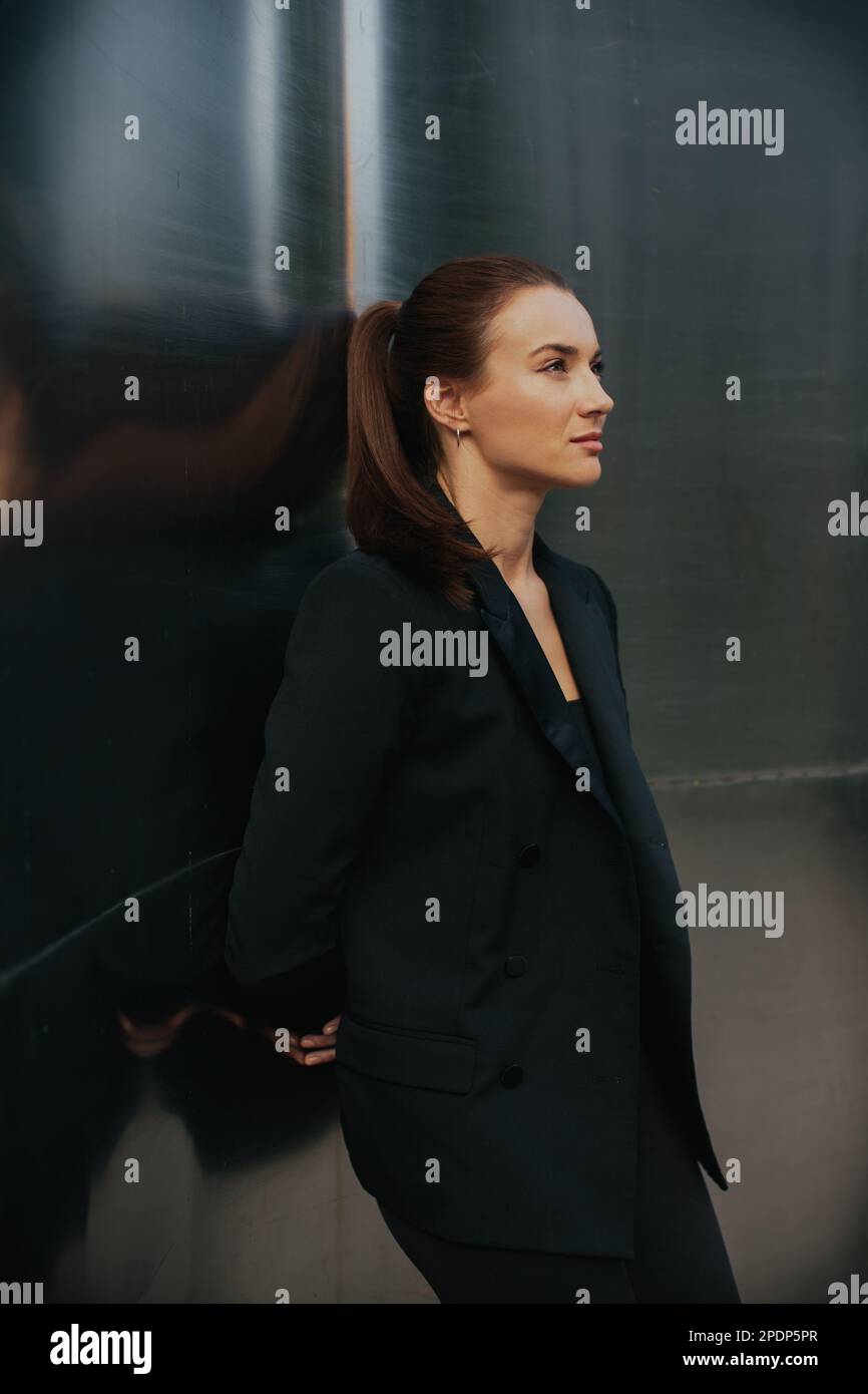 Mode Street style portrait de jolie fille en costume noir. Magnifique brunette posé à l'extérieur. Banque D'Images