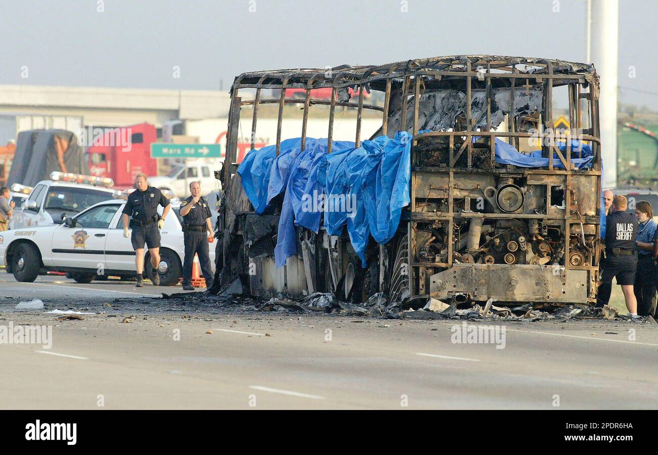Emergency crews investigate the scene where a bus caught fire and exploded on northbound Interstate 45, Friday, Sept. 23, in Wilmer, Texas. The bus carrying elderly evacuees from Hurricane Rita caught fire and was rocked by explosions early Friday on a gridlocked highway near Dallas, killing as many as 24 people, authorities said. The bus, with about 45 people on board, had been traveling since Thursday. (AP Photo/Matt Slocum) Banque D'Images