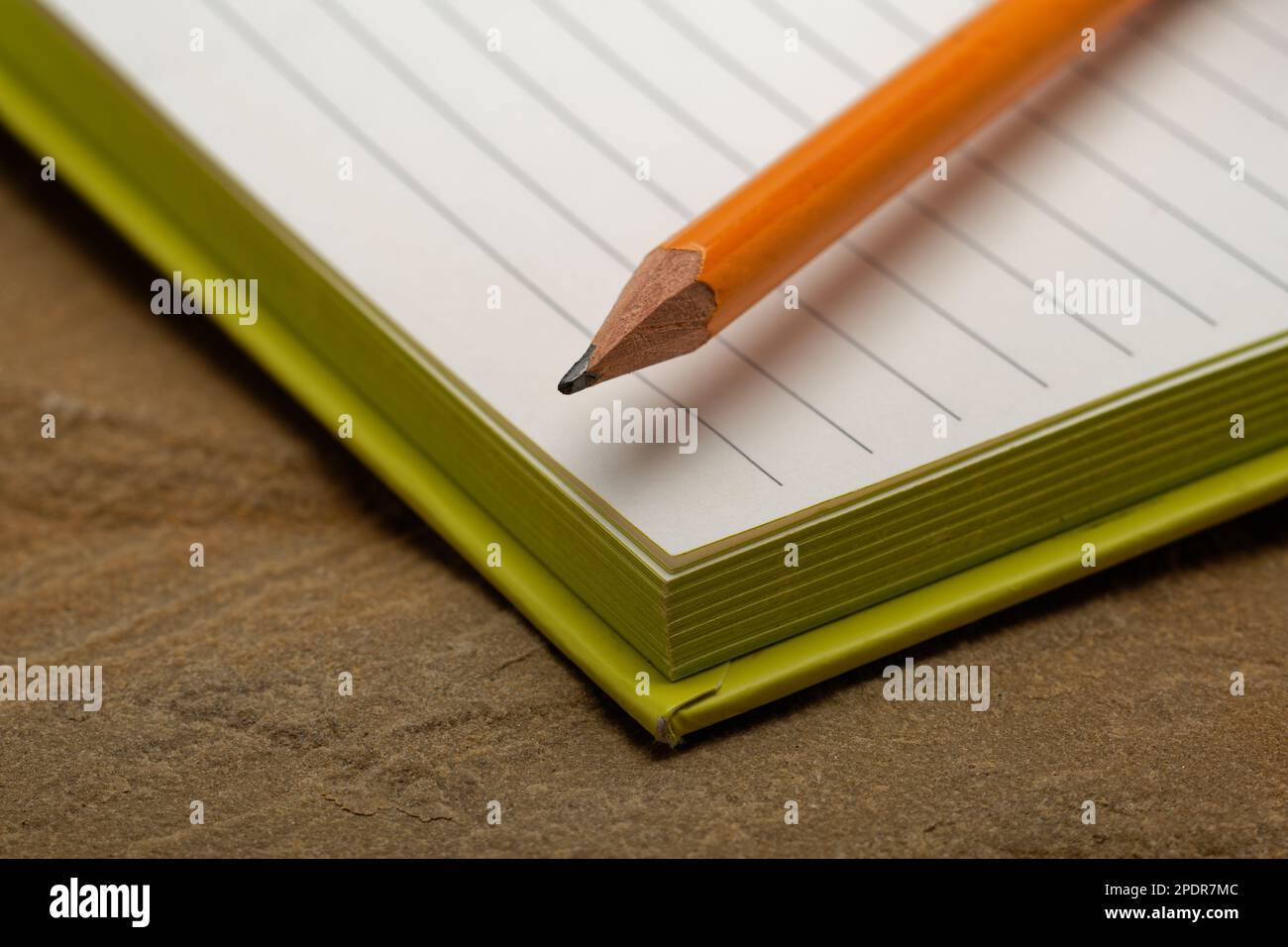 Un carnet doublé avec un crayon. Prêt à prendre des notes, à esquisser des idées et à rédiger des plans. Crayon et papier à portée de main. Banque D'Images