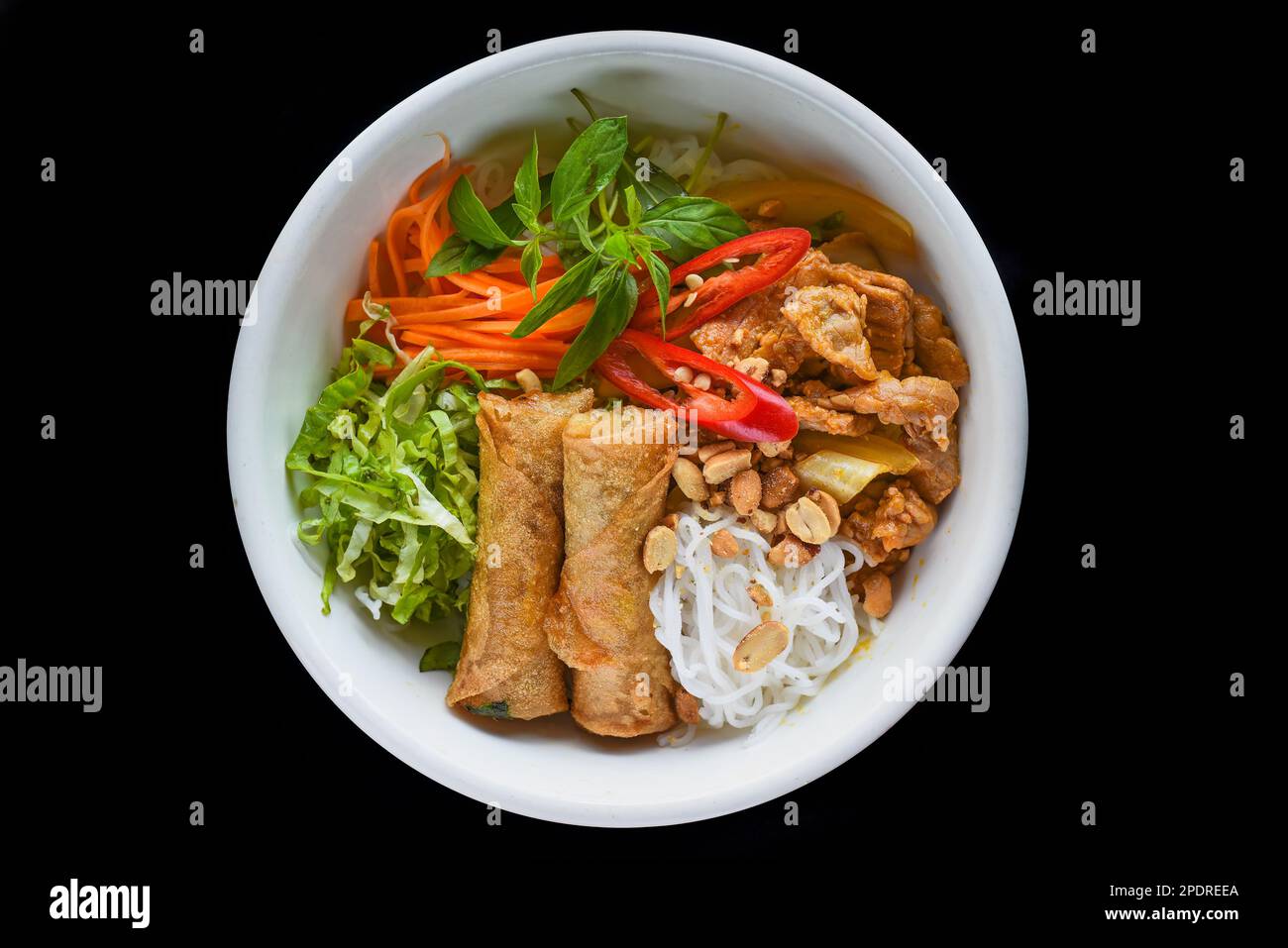 Rouleaux de printemps vietnamiens frits traditionnels au porc servis avec des nouilles de riz, du bœuf frit et des arachides Banque D'Images