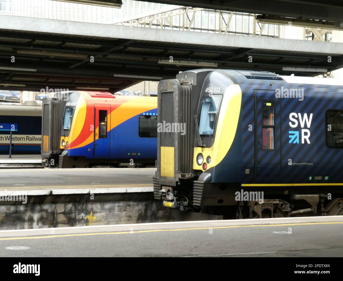 Gare de Waterloo à Londres avec trois trains électriques dans des liveries colorées contrastées Banque D'Images