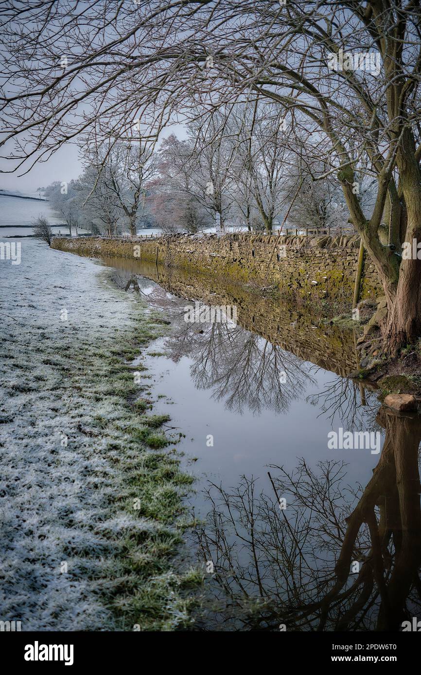 Champs utilisés pour le pâturage des moutons inondés par la rivière aire et recouverts de neige laissant des reflets clairs dans les eaux d'inondation Banque D'Images