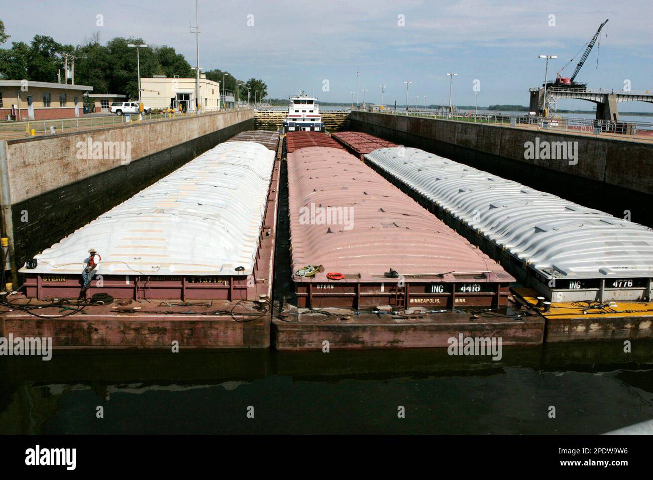 A towboat and its barges are shown in the channel at Lock and Dam 25 at Winfield, Mo., Friday, Aug. 19, 2005. Congress is considering legislation to spend nearly $2 billion to build seven larger locks along the Mississippi River to help river traffic move more quickly. Long barge tows moving through the older locks have to be split up before passing through, a process that takes about two hours. (AP Photo/James A. Finley) Banque D'Images