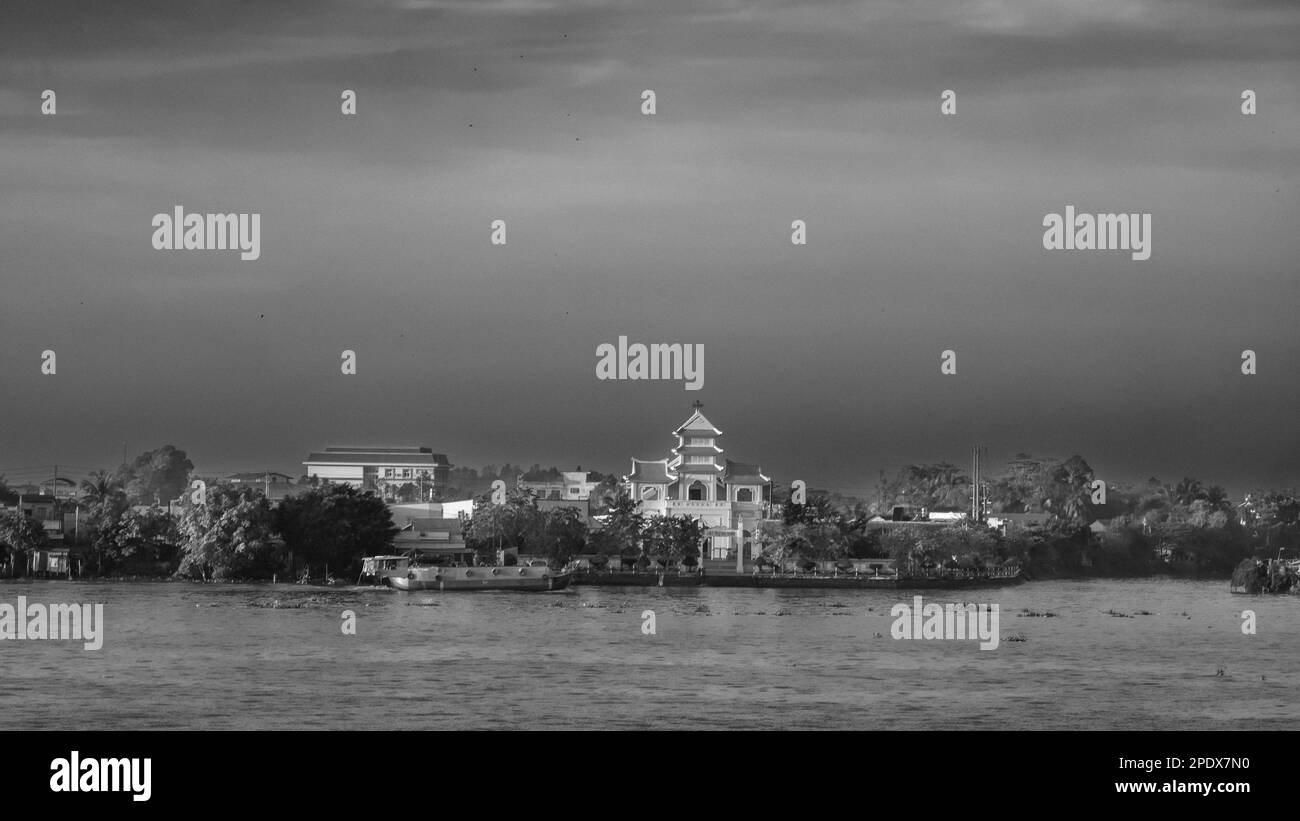 Une église de style oriental et d'autres bâtiments sur les rives du Mékong à long Xuyen dans le delta du Mékong au Vietnam. Banque D'Images