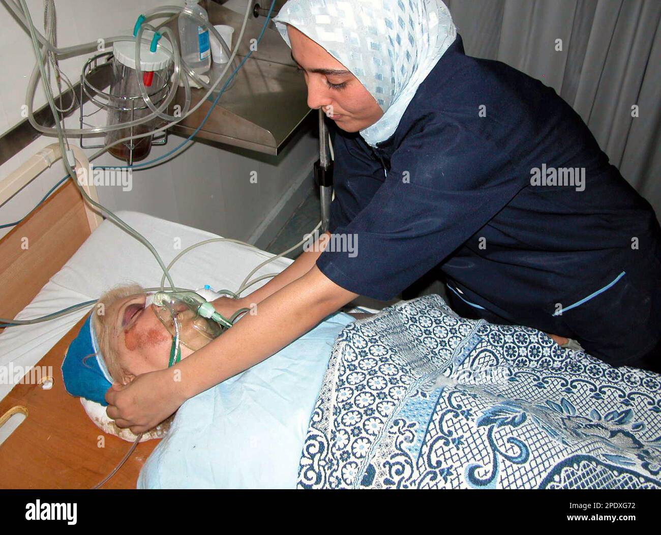 An Egyptian nurse comforts injured Greek woman, Sola, 53, at the Pyramids hospital in sharm el sheik, Egypt, Saturday Aug.20, 2005. A tour bus blew a front tire on a Sinai mountain road and crashed in a ravine Friday, killing seven Cypriots, police said. (AP Photo) Banque D'Images