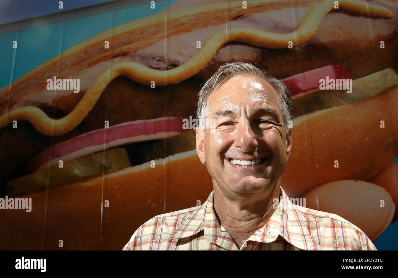 Johnsonville Sausage Company CEO Ralph Stayer stands in front of a picture of a bratwurst
