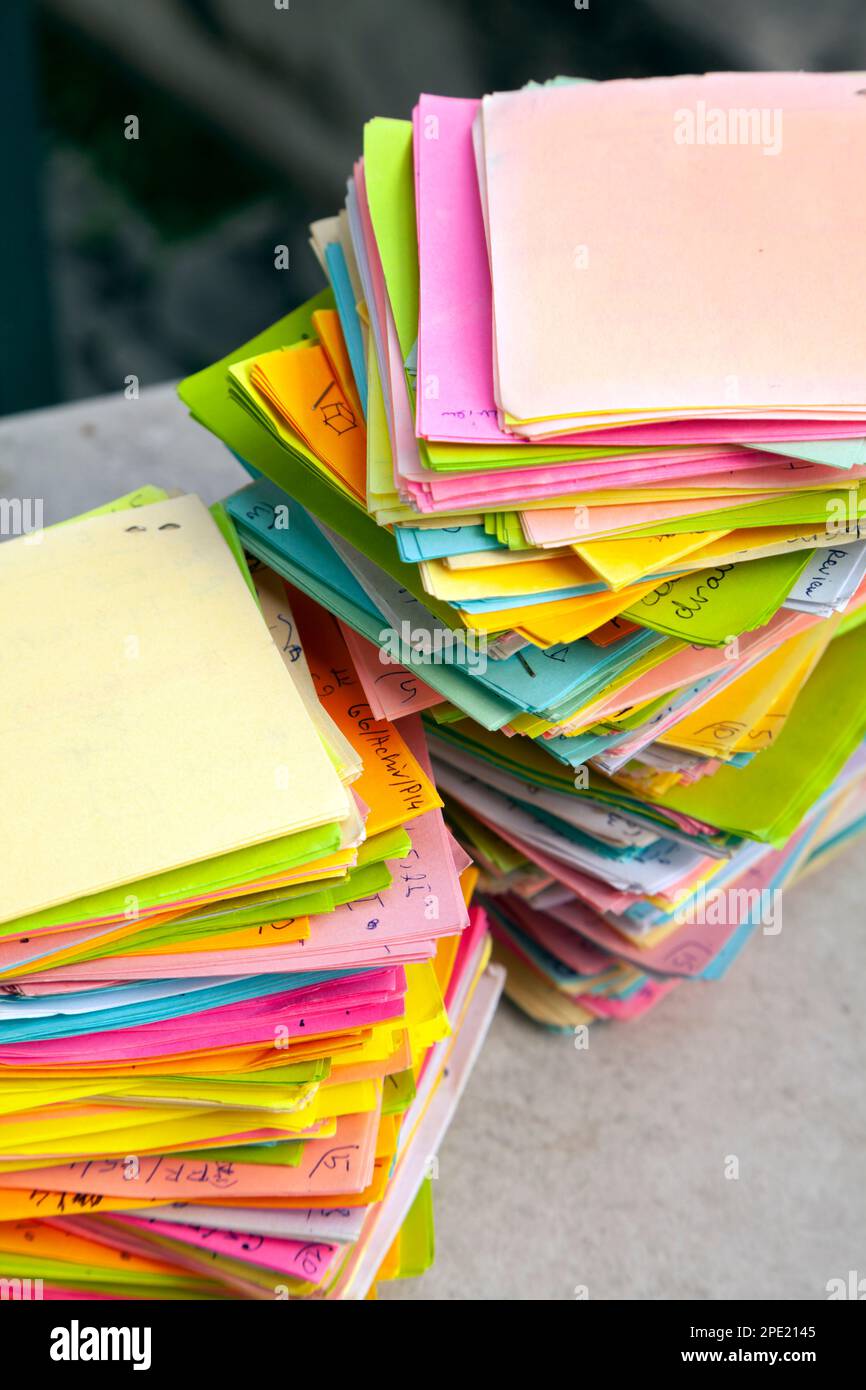 Notes mémo multicolores avec tâches stockées de manière chaotique dans 2 piles. Dépassement de travail représenté par une pile de papiers-notes avec des tâches Banque D'Images