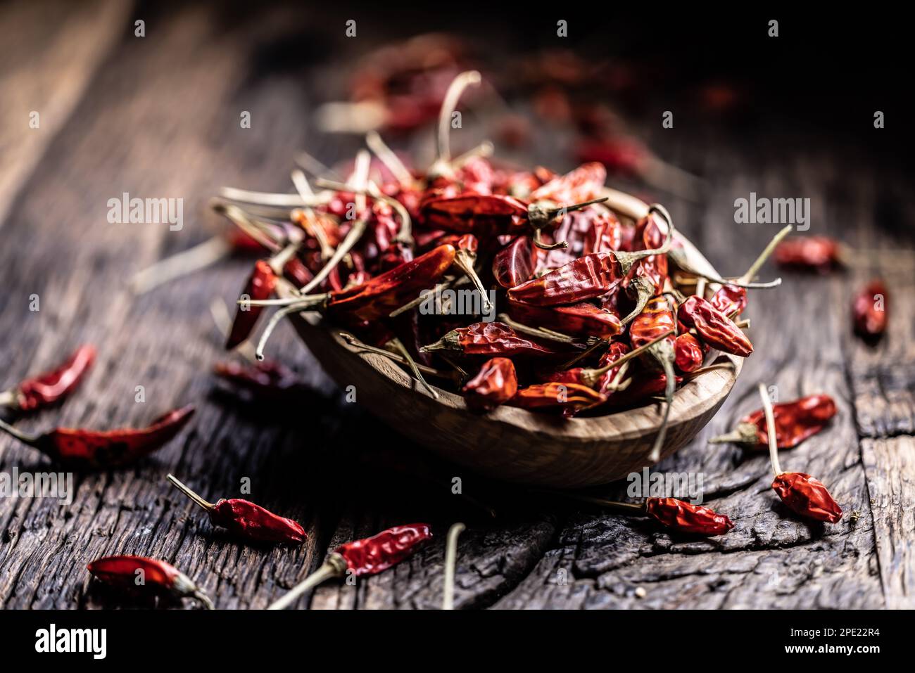 Piments séchés dans un bol de bois sur une table rustique. Banque D'Images