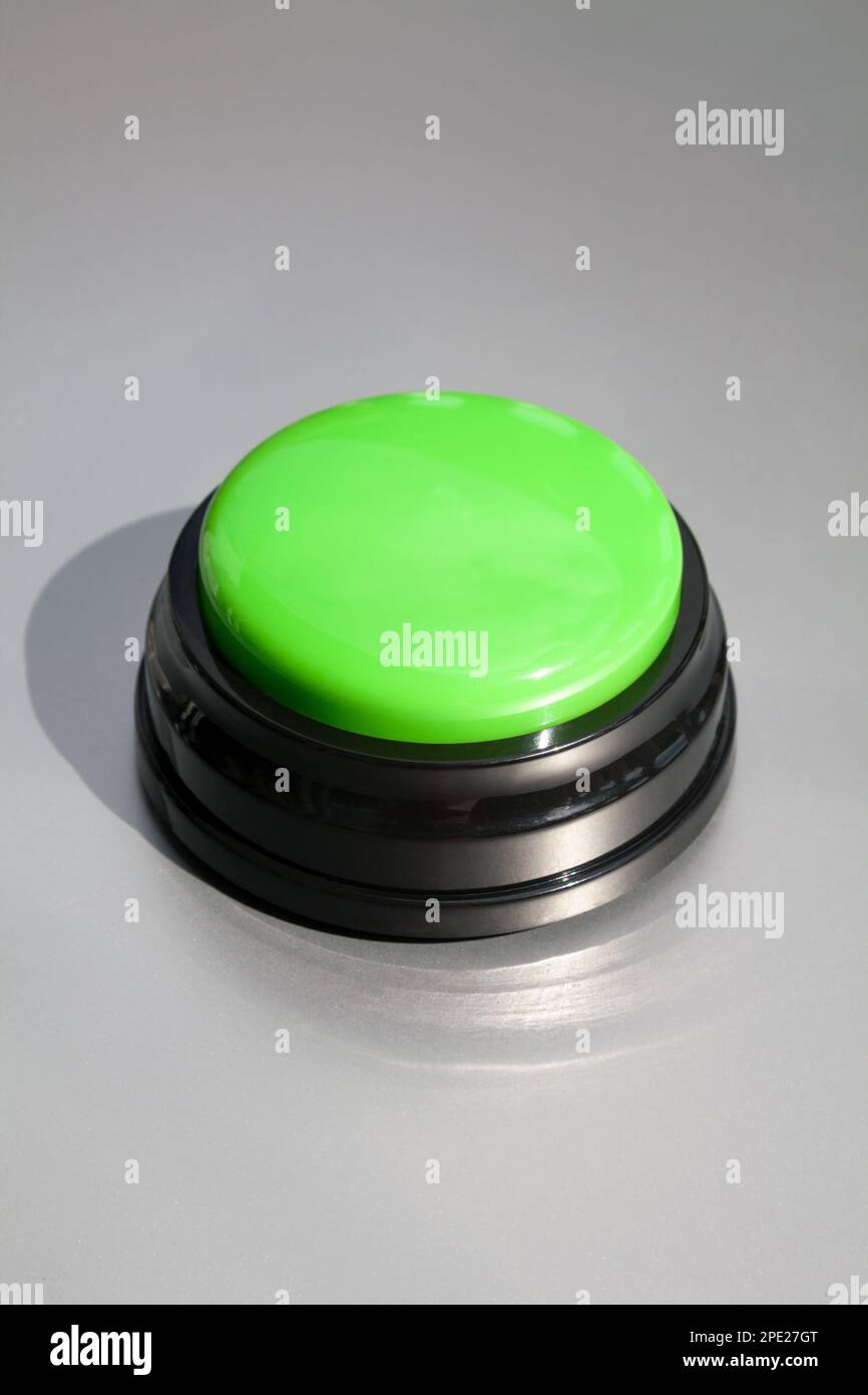 Grand buzzer vert pour les réponses dans une série de jeux isolée sur gris. Bouton sans fil pour l'enseignement des enfants ou l'entraînement des animaux Banque D'Images