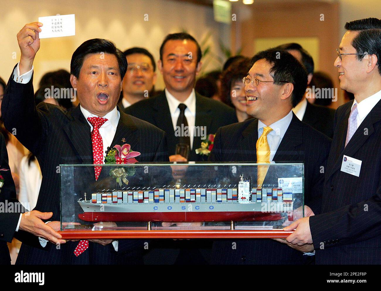 China COSCO Executive President and CEO Wei Jiafu, left, presents a  container ship model to Carlson Tong, second from right, listing committee  deputy chairman, and Chow Man Yiu, right, Cheif Executive of