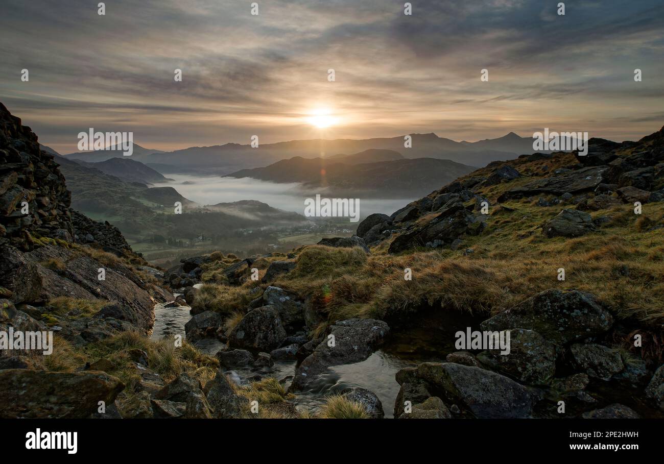 Snowdonia lever de soleil spectaculaire avec brume dans la vallée en contrebas Banque D'Images