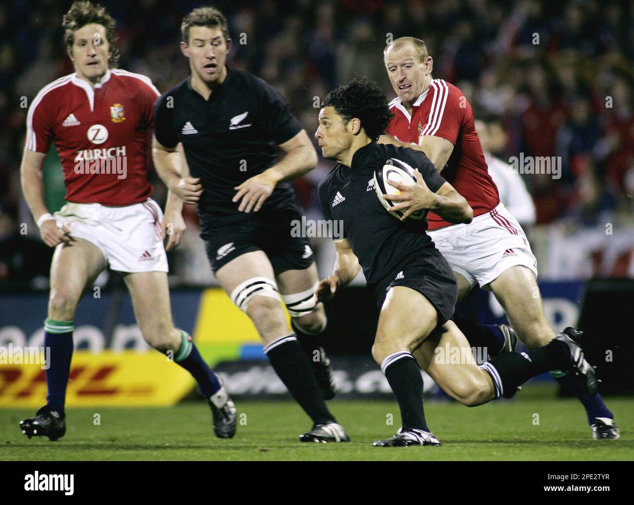All Black winger Doug Howlett, second from right, is chased by British and Irish Lions winger Gareth Thomas, right, as Lions player Will Greenwood, left, and All Black Chris Jack look on during the first test in Christchurch, New Zealand, Saturday, June 25, 2005. The All Blacks defeated the Lions 21-3. (AP Photo/Mark Baker) ** NOT FOR USE ON MOBILE DEVICES ** Banque D'Images