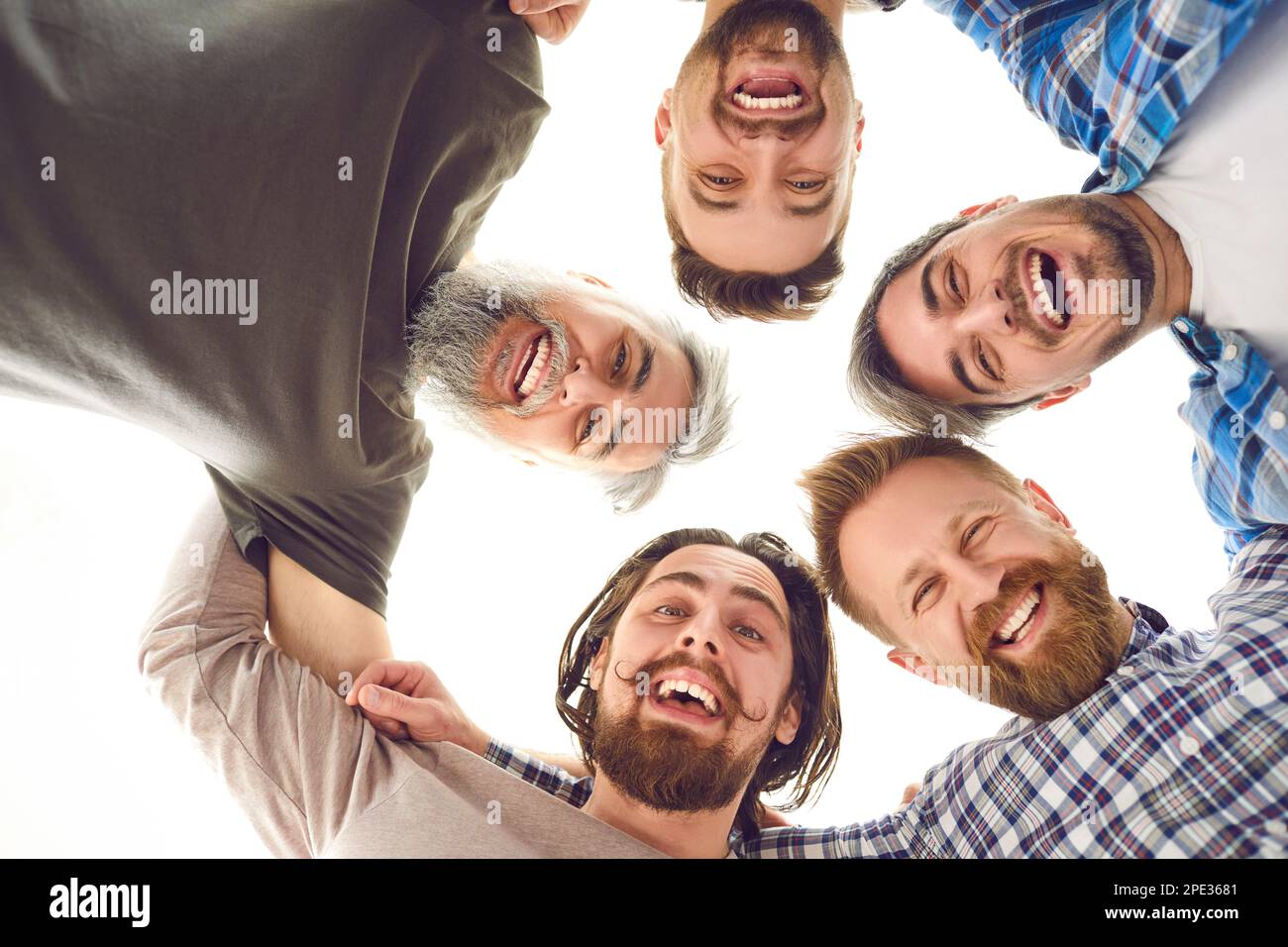 Groupe d'amis hommes heureux qui se mêlent, regardant l'appareil photo, souriant et riant Banque D'Images
