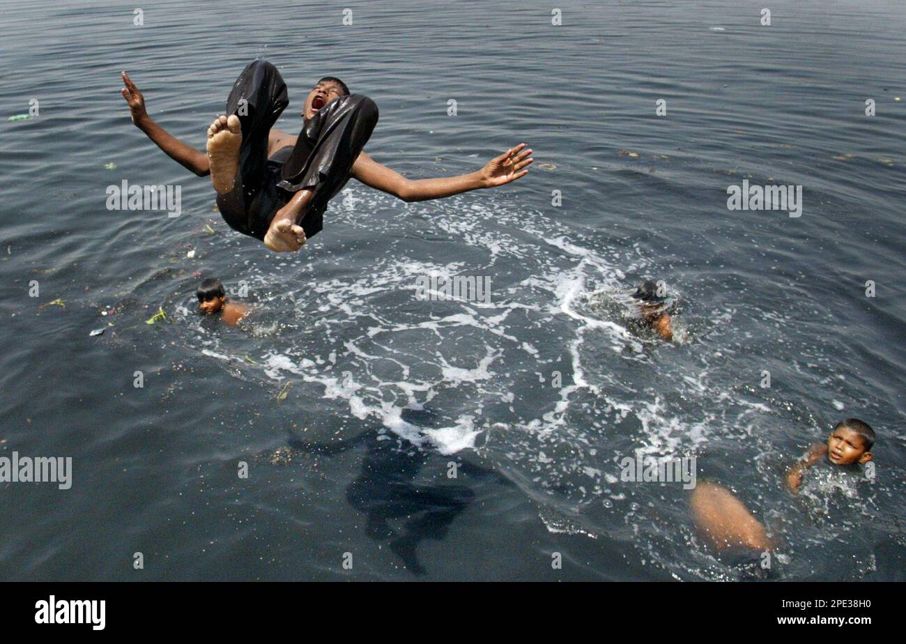 Children jump into the river Yamuna in New Delhi, India, Monday, June 20, 2005. Many parts of India are having heat wave conditions as temperature rose above 44 Celsius (111.2 Fahrenheit). The death toll in India due to heat wave is more than 150. (AP Photo/Manish Swarup) Banque D'Images