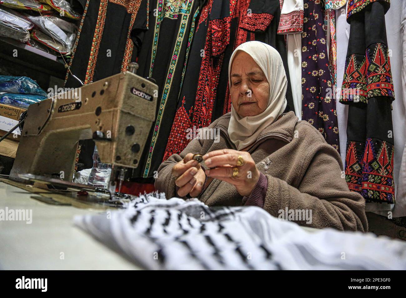 Farha Dana, vu dans sa petite boutique de couture de vêtements et de sacs pour femmes dans la vieille ville où elle a travaillé pendant plus de 45 ans, comme elle a hérité de la profession de son père. La couturière palestinienne a 65 ans et travaille sur la route Al-Wad près de Bab Al-Majlis, une des portes de la mosquée Al-Aqsa. Banque D'Images