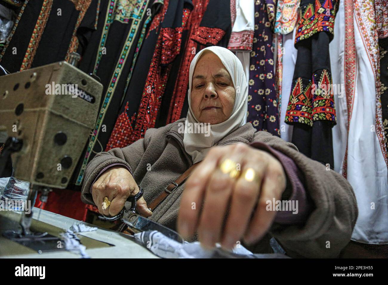 Farha Dana, a vu dans son petit magasin couper du matériel à coudre dans la vieille ville où elle a travaillé pendant plus de 45 ans, comme elle a hérité de la profession de son père. La couturière palestinienne a 65 ans et travaille sur la route Al-Wad près de Bab Al-Majlis, une des portes de la mosquée Al-Aqsa. Banque D'Images