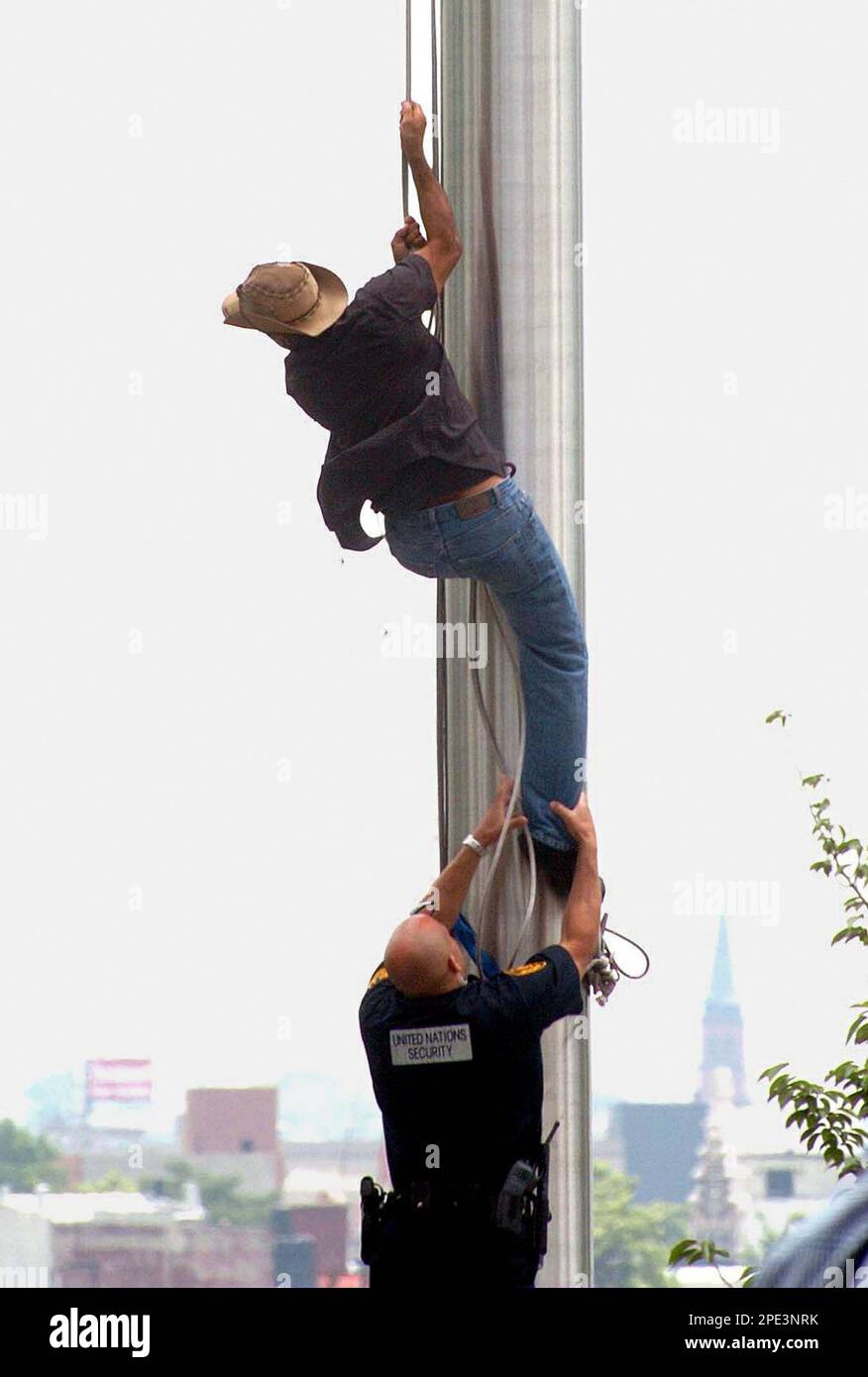 A United Nations security officer stops Puerto Rican activist Alberto de Jesus, known as "Tito Kayak", while trying to climb a flag pole at the U.N. headquarters in New York, Monday, June 13, 2005. "Tito Kayak" was detained for his attempt to replace the U.N. flag with a Puerto Rican flag, which is not present at the building, as the Caribbean island is a U.S. territory. His actions happened during a meeting of the U.N. "decolonization" committee to review a resolution presented annually by Cuba for Puerto Rican "free-determination" status. (AP Photo/Humberto Trias) Banque D'Images
