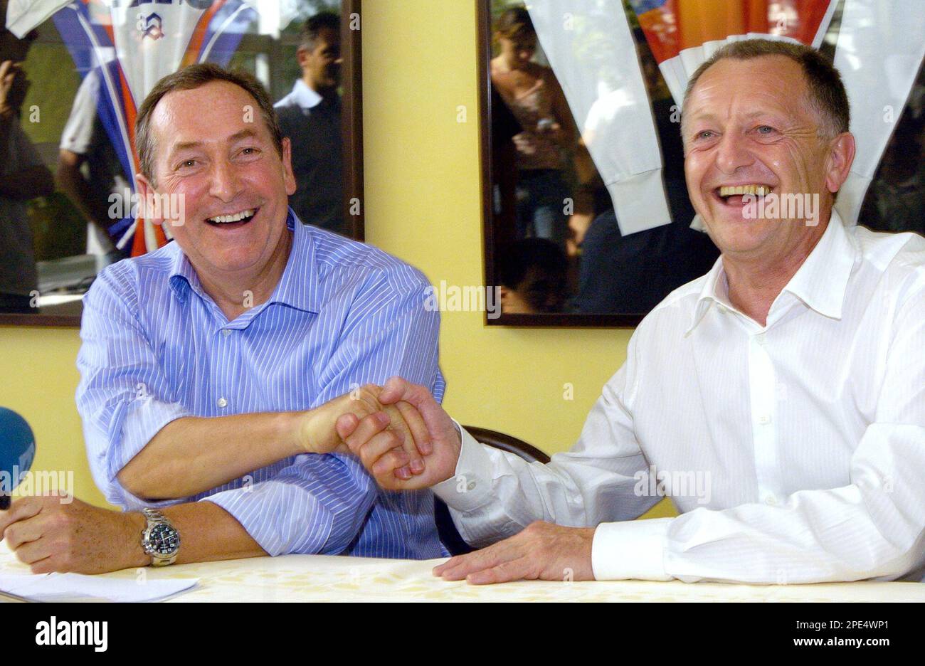 Former Liverpool coach Gerard Houllier of France, left, shakes hands with French soccer team Lyon president Jean Michel Aulas during a press conference in Lyon, central France, Sunday May 29, 2005, to announce Houllier was named coach of the team as the replacement of Paul Le Guen. Lyon has won a record-equaling four straight first division titles. (AP Photo/Patrick Gardin) Banque D'Images