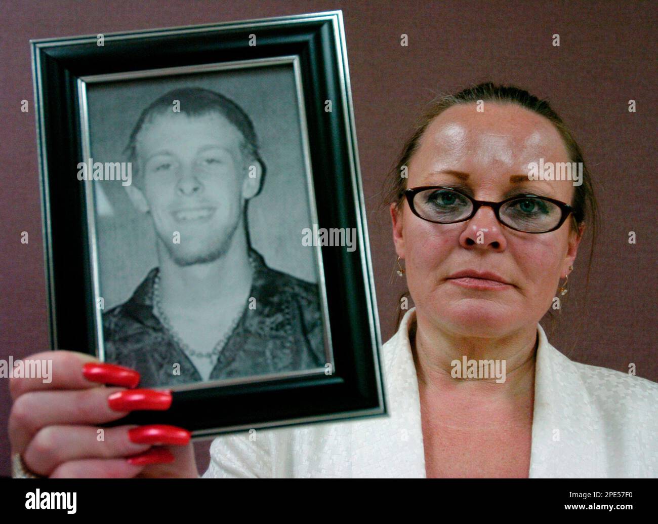 Judy Denisse holds a photograph of her son Alex Hickenbottom, Tuesday