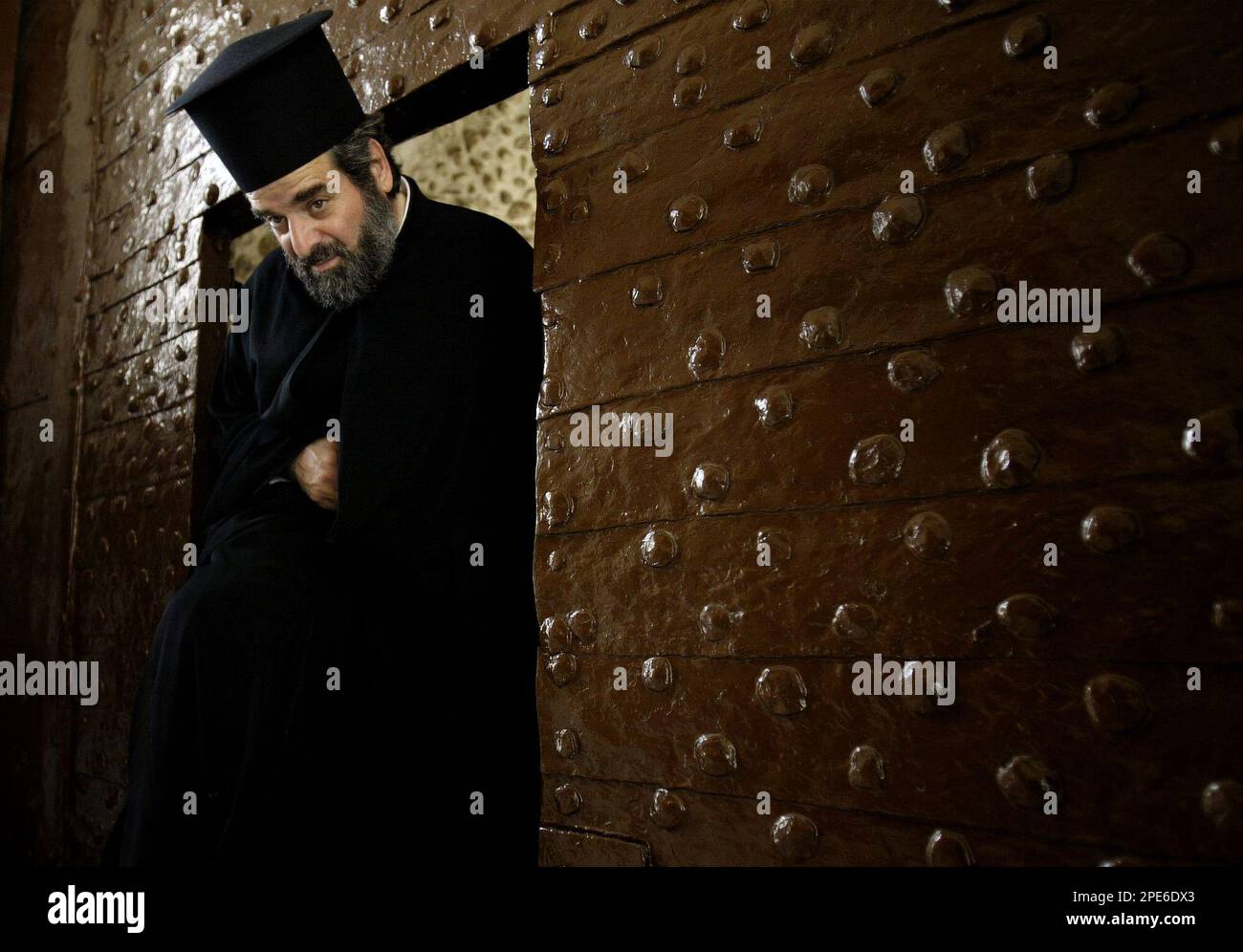 An unidentified Greek-Orthodox priest walks through the main entrance of the Greek Orthodox Patriarchate in Jerusalem's Old City Sunday May 8, 2005. Members of the Synod of the Greek Orthodox Church in Jerusalem sent a letter to Jordan's Interior Minister demanding the dismissal of Greek Orthodox Patriarch Irineos I over his alleged role in a controversial Jerusalem property deal, a church official and lawmaker both said Sunday.(AP Photo/Oded Balilty) Banque D'Images