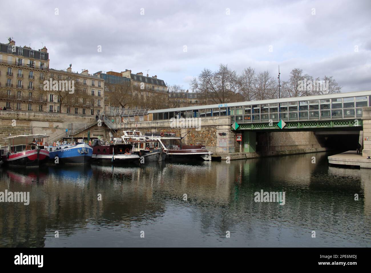 Vue sur un pont au-dessus du Canal Saint Martin une voie navigable parisienne qui mène directement à la Seine située à Paris France. Banque D'Images