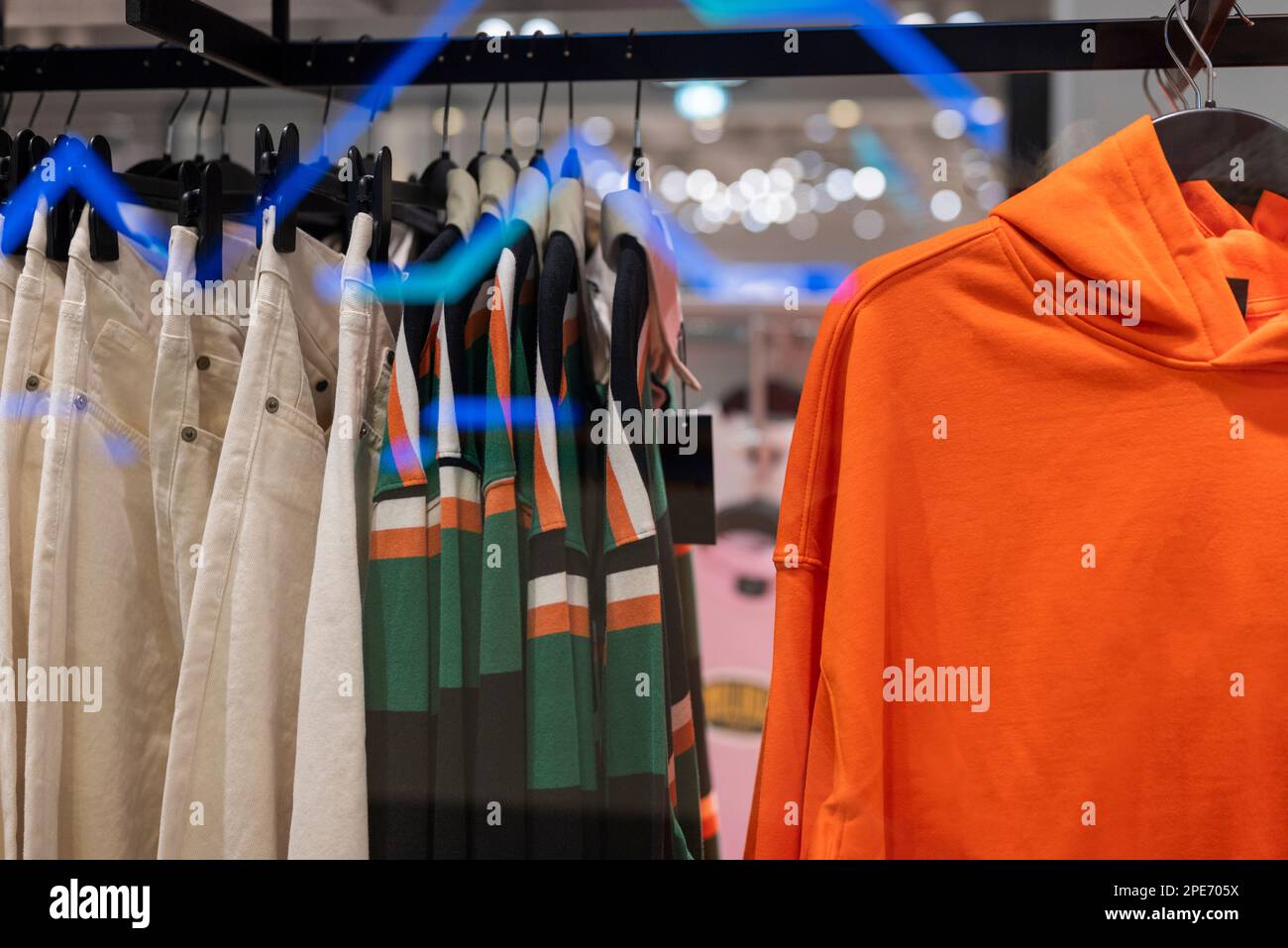 des vêtements élégants sont suspendus sur des cintres dans un magasin dans un centre commercial Banque D'Images