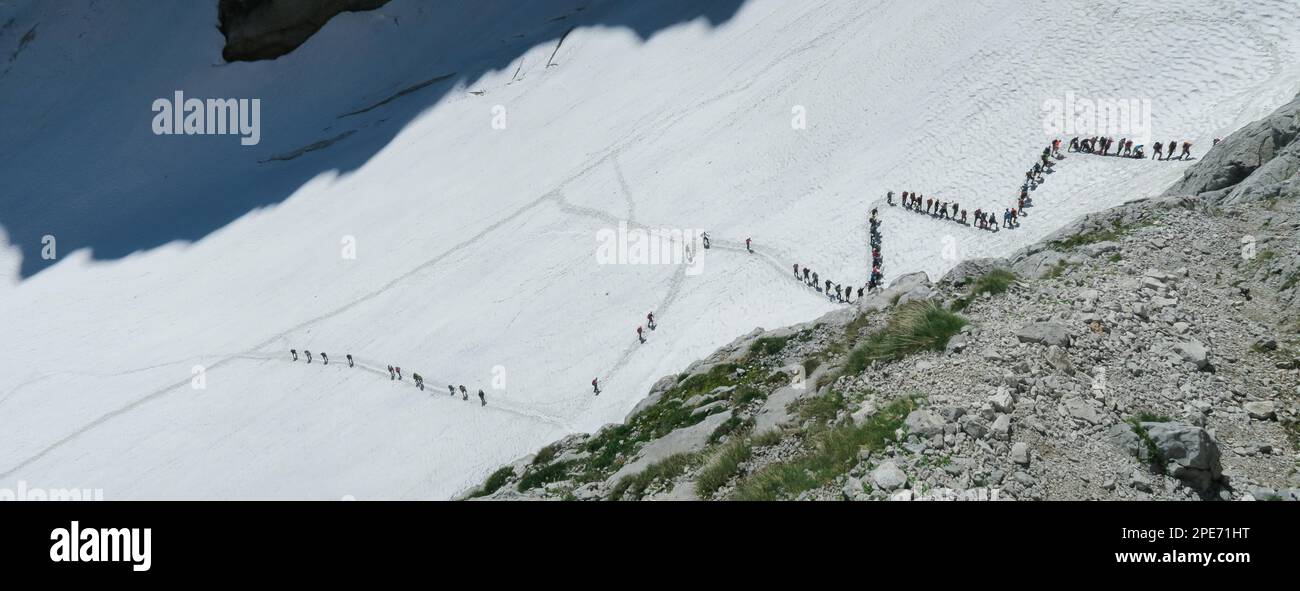 Vue d'en haut sur les personnes marchant sur le glacier zigzag. File d'attente importante, congestion. Massif du Zugspitze dans les alpes bavaroises, Dolomites, Italie, Europe Banque D'Images